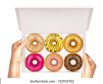 Realistic colorful donuts with sprinkles, glaze and sesame seeds in open white box in hands vector illustration