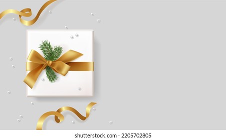 Realistic gift box on a gray background with Christmas tree branches with a ribbon and a bow. decorative objects. Sale banners, flyers and brochures. Holiday, Christmas, New Year. Top view, flat lay