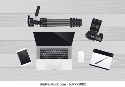 Realistic modern laptop with wireless mouse, graphic tablet, DSLR camera and tripod. Photographer's tools. Top view. Vector illustration.