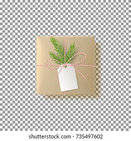 Realistic paper gift box isolated on transparent backdrop. Vector illustration. Top view on Xmas gift with fir tree branch and tag. Template for greeting card on Christmas or New Year.