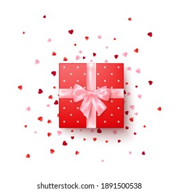 Realistic red gift box with pink silk bow decorated confetti top view. Vector illustration