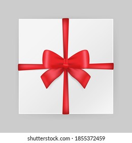 Realistic red ribbon banner on white backdrop. Box with bow knot, great design for any purposes. Holiday concept. Xmas present. Realistic template. Vector design template.