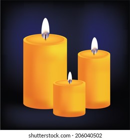 Realistic three yellow candles on dark background 