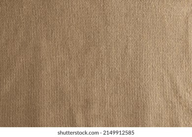 Realistic vector illustration of a beige knitted carpet close-up. Textile texture on a beige background. Detailed warm yarn background. Natural wool fabric, sweater fragment.
