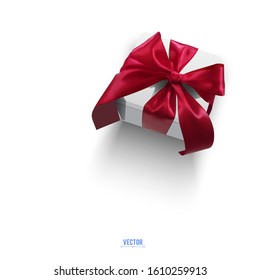 Realistic vector illustration of a gift box with a red ribbon and a bow on a white background. 3D white box tied with red festive ribbon.