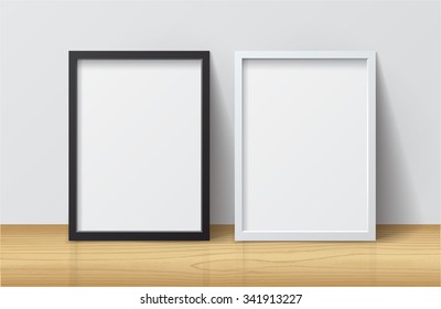 Realistic White and Black Blank Picture frame, standing on Light Wood Floor at
White Wall from the Front. 
Design Template for Mock Up. Vector illustration