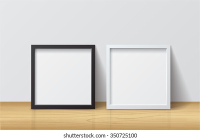 Realistic White and Black Blank Square Picture frame, standing on Light Wood Floor at
White Wall from the Front. 
Design Template for Mock Up. Vector illustration