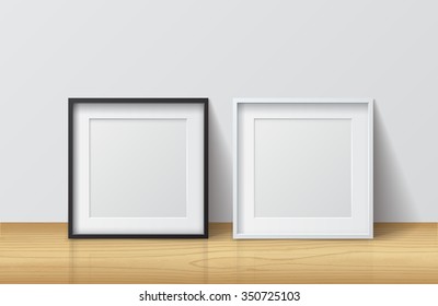 Realistic White and Black Blank Square Picture frame, standing on Light Wood Floor at
White Wall from the Front. 
Design Template for Mock Up. Vector illustration