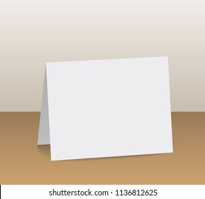 Realistic white blank folded paper card standing on wooden table top - vector