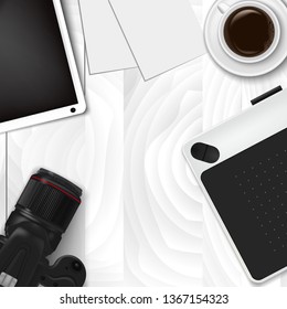 Realistic workplace organization. Top view with textured table, tablet, graphic tablet, professional DSLR camera, papers, glass, and coffee mug. Work desk for office with stationery elements on the ta