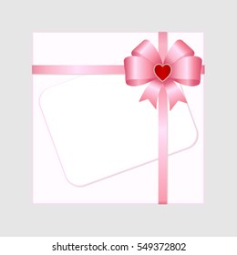 Rectangle white paper card with pink ribbon and tied bow.
