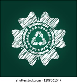 recycle icon inside chalk emblem written on a blackboard
