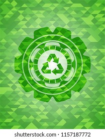 recycle icon inside green emblem with triangle mosaic background