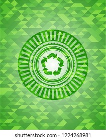 recycle icon inside green emblem with triangle mosaic background