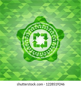 recycle icon inside green emblem with triangle mosaic background