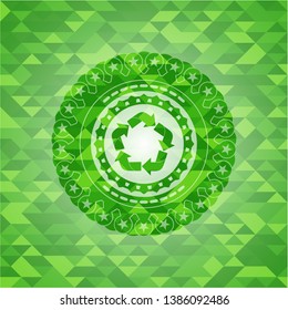 recycle icon inside green emblem with triangle mosaic background