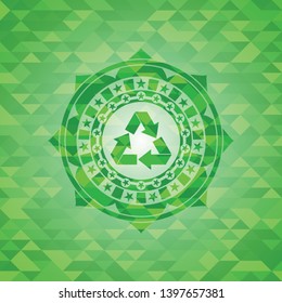 recycle icon inside green emblem with triangle mosaic background