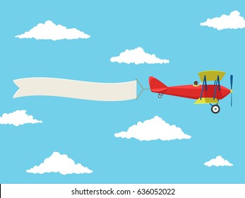 Red airplane with pilot and advertising banner in the cloudy sky