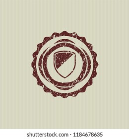 Red armor icon inside distressed rubber seal with grunge texture