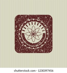 Red atom icon inside distressed grunge style stamp