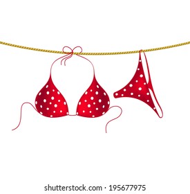 Red bikini suit with white dots hanging on rope