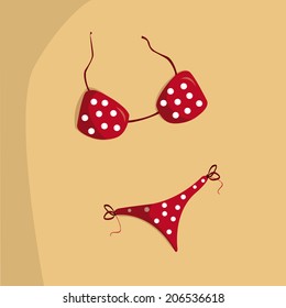 a red bikini with white dots on the beach