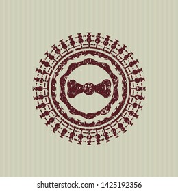 Red bow tie icon inside distressed rubber seal