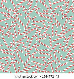 Red candy canes on blue background, winter seamless pattern Vector illustration.