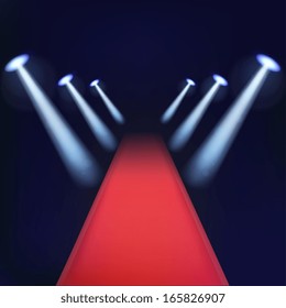 Red carpet with spotlights. Rays of light on a dark background