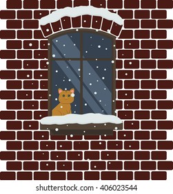 Red Cat Looking Outside In The Snowy Window Of A Brick House