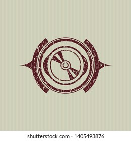 Red CD or DVD disc icon inside distressed rubber stamp with grunge texture