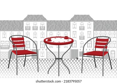 Red chairs and a table of a street cafe against the background of the houses of an old European city