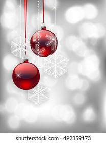 Red Christmas baubles and snowflake ornaments on light gray bokeh background.