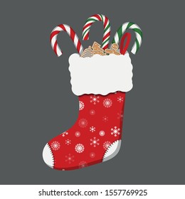 red Christmas stocking with candy canes and gingerbread on grey background