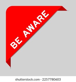 Red color of corner label banner with word be aware on gray background