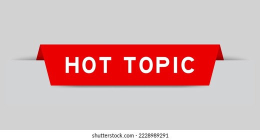 Red color inserted label with word hot topic on gray background