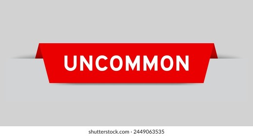 Red color inserted label with word uncommon on gray background