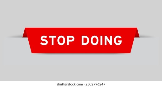 Red color inserted label with word stop doing on gray background