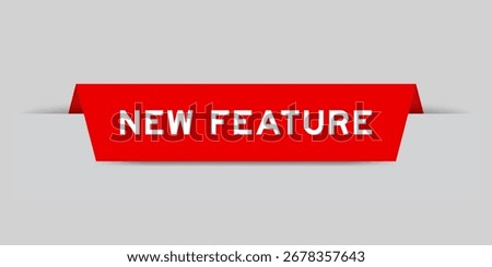 Red color inserted label with word new feature on gray background