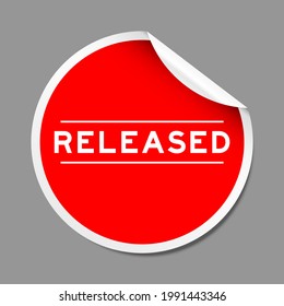 Red color peel sticker label with word released on gray background