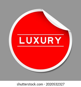Red color peel sticker label with word luxury on gray background