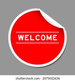 Red color peel sticker label with word welcome on gray background