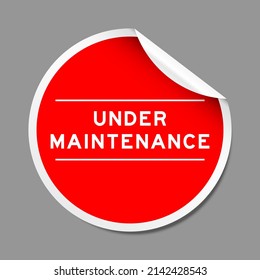 Red color peel sticker label with word under maintenance on gray background