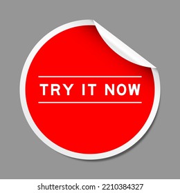 Red color peel sticker label with word try it now on gray background