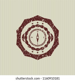 Red compass icon inside distressed rubber grunge texture seal