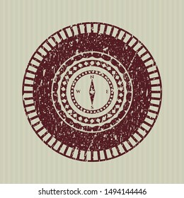 Red compass icon inside rubber grunge stamp