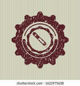 Red cutter icon inside rubber seal with grunge texture