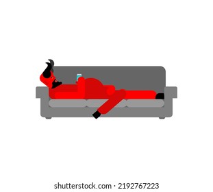 Red Devil relax on couch. Satan sleeps on couch