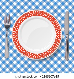 Red dish with pattern of chaotic white polka dot placed on blue classic table cloth