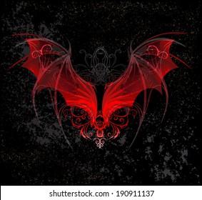 Red dragon wings decorated with pattern on black textural background.